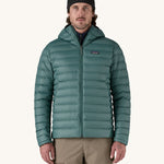 A man wearing the Patagonia Men's Down Sweater Hoody Jacket in a Wetland Blue colour.