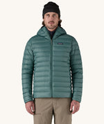 A man wearing the Patagonia Men's Down Sweater Hoody Jacket in a Wetland Blue colour.