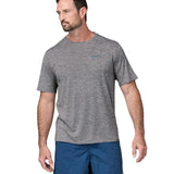 A man wearing a Patagonia Men's Capilene Cool Daily Graphic Shirt with a Waters / Feather Grey design, showing the front of the t-shirt. 