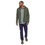 Man stood on a white background wearing the Patagonia thermal fleece Better Sweater Jacket in the Industrial Green colour