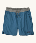 patagonia mens baggies shorts in a dark blue colour on a cream background.