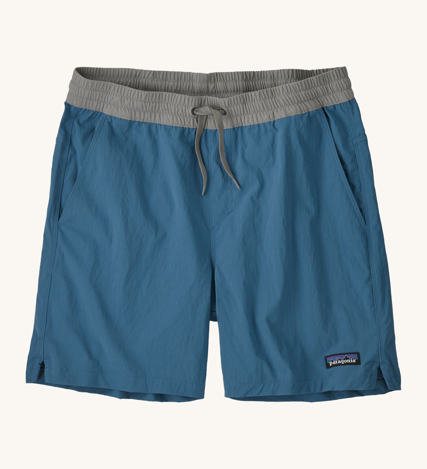 patagonia mens baggies shorts in a dark blue colour on a cream background.