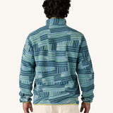 A man wearing the Patagonia Men's Lightweight Synchilla Snap-T Fleece in Quilty Fitz / Wetland Blue. He is facing away from the camera showing the back of the top. 