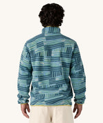 A man wearing the Patagonia Men's Lightweight Synchilla Snap-T Fleece in Quilty Fitz / Wetland Blue. He is facing away from the camera showing the back of the top. 