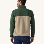 A man facing away from the camera wearing a Patagonia Men's Lightweight Synchilla Snap-T Fleece in a Seabird Grey and green colour showing the back of it.