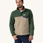 A man wearing a Patagonia Men's Lightweight Synchilla Snap-T Fleece in a Seabird Grey and green colour.  