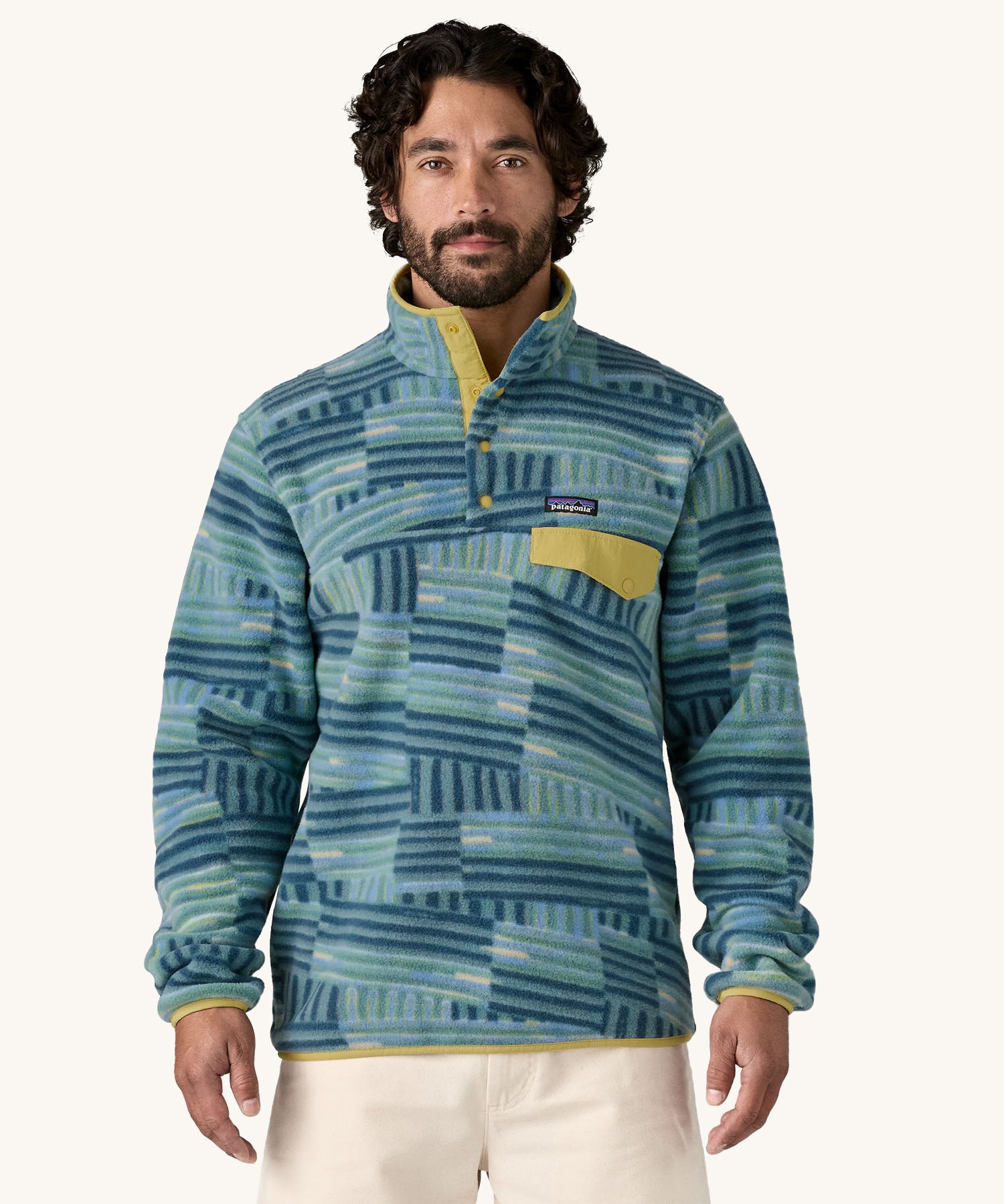 A man wearing the Patagonia Men's Lightweight Synchilla Snap-T Fleece in Quilty Fitz / Wetland Blue.