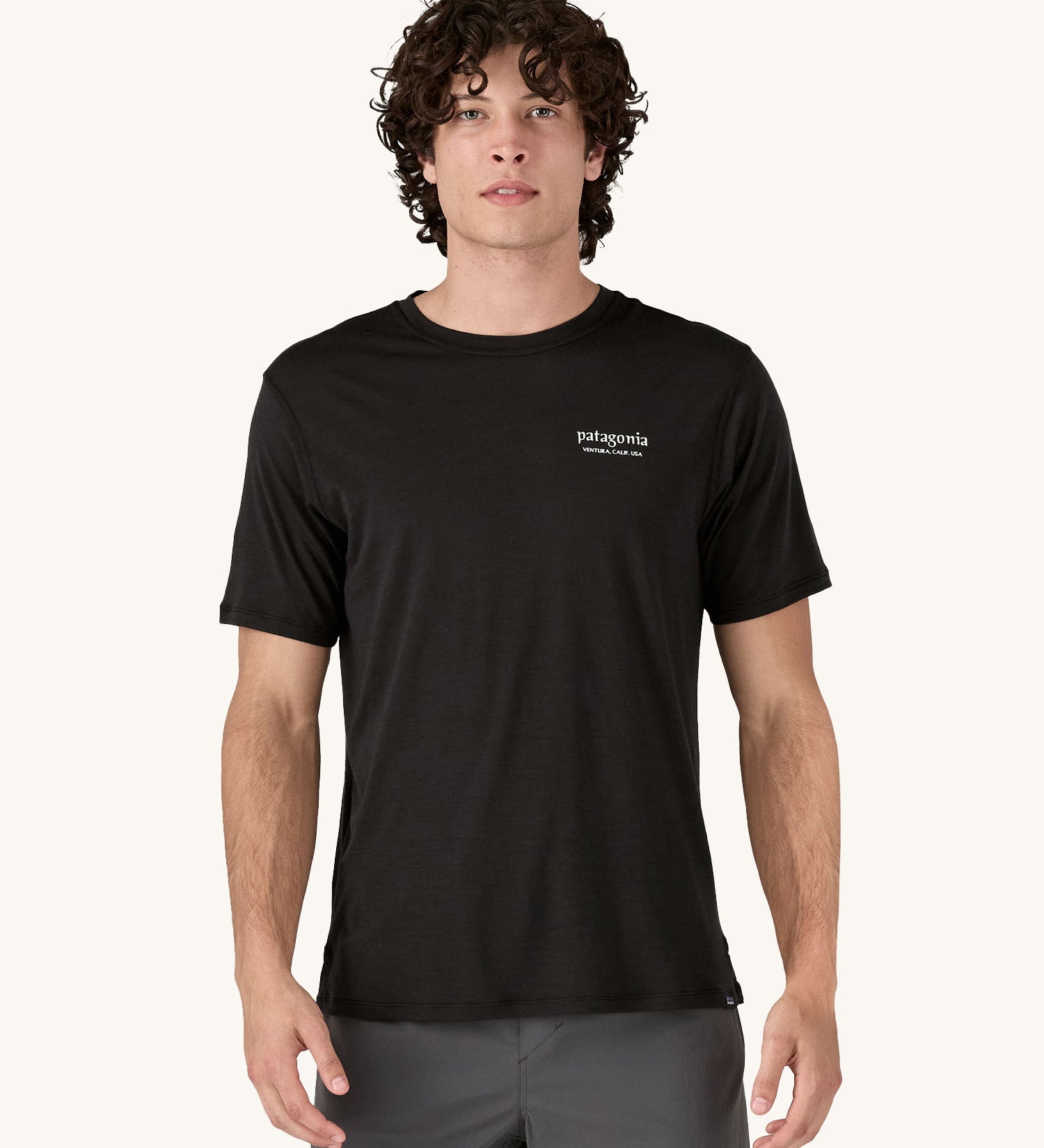 A man wearing the Patagonia Men's Capilene Cool Merino Graphic Shirt with a Heritage Header design in Black.