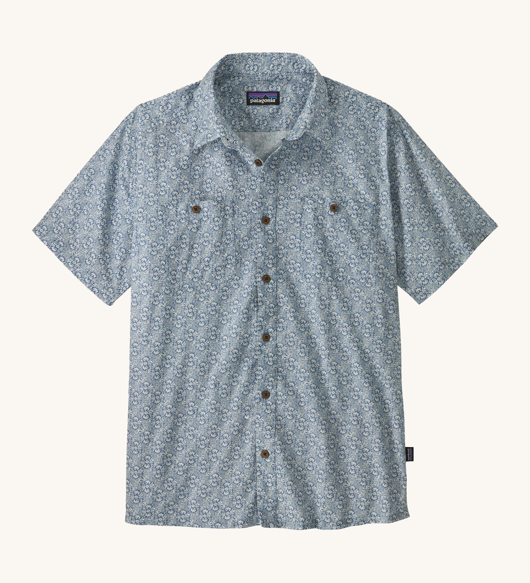 Patagonia Back Step Shirt, made with a blend of 55% industrial hemp and 45% organic cotton. In light blue with an understated Mountain Breeze print, it features short sleeves, coconut buttons, and two chest pockets. 