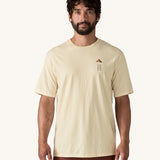 A man wearing a cream coloured Patagonia Men's Organic T-Shirt. This t-shirt is a part of a wide range of Patagonia clothing and accessories available here at Babipur. 