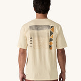 A view of the back of a man wearing a cream coloured Patagonia Men's Organic T-Shirt. This t-shirt is a part of a wide range of Patagonia clothing and accessories available here at Babipur. 