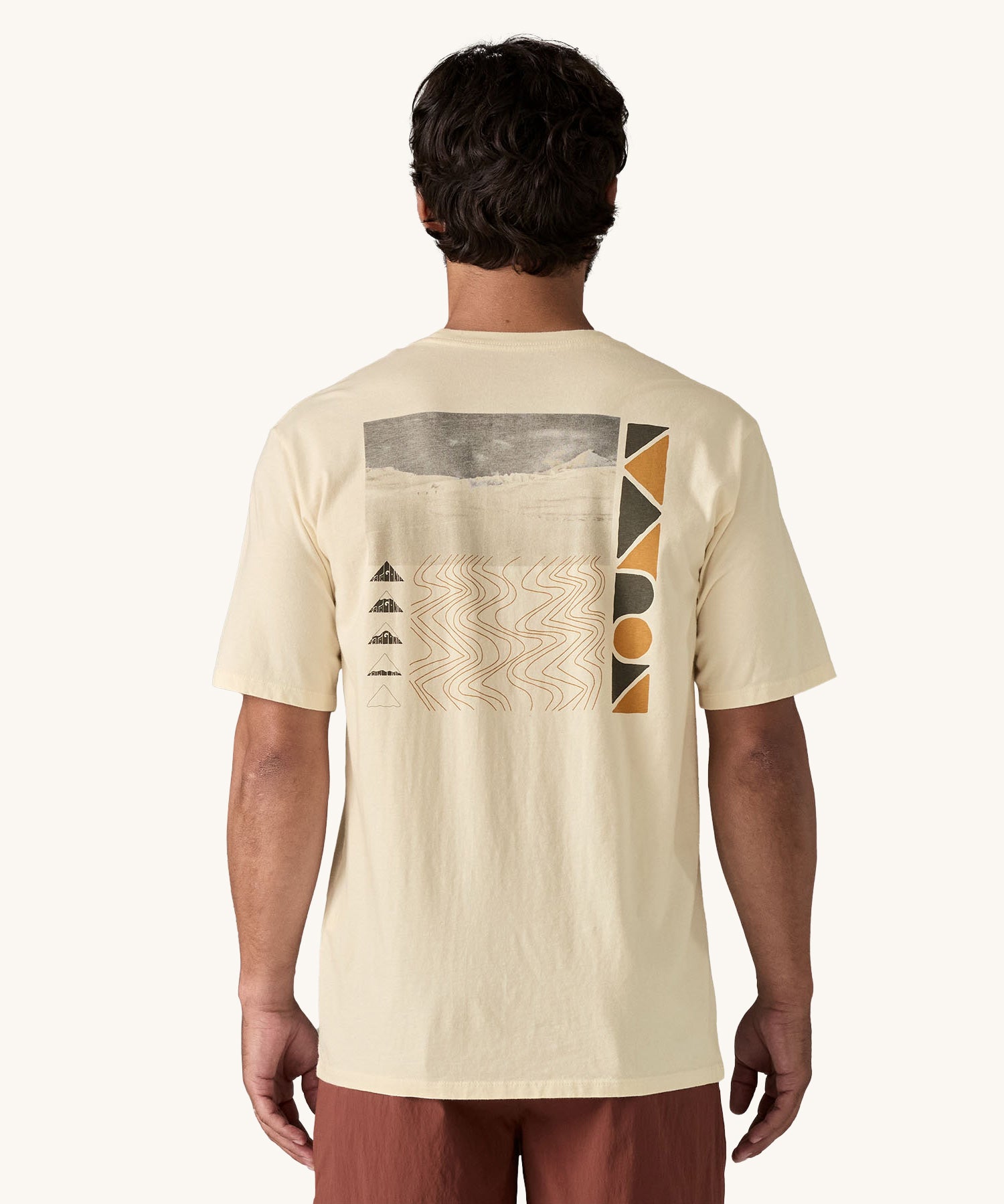 A view of the back of a man wearing a cream coloured Patagonia Men's Organic T-Shirt. This t-shirt is a part of a wide range of Patagonia clothing and accessories available here at Babipur. 