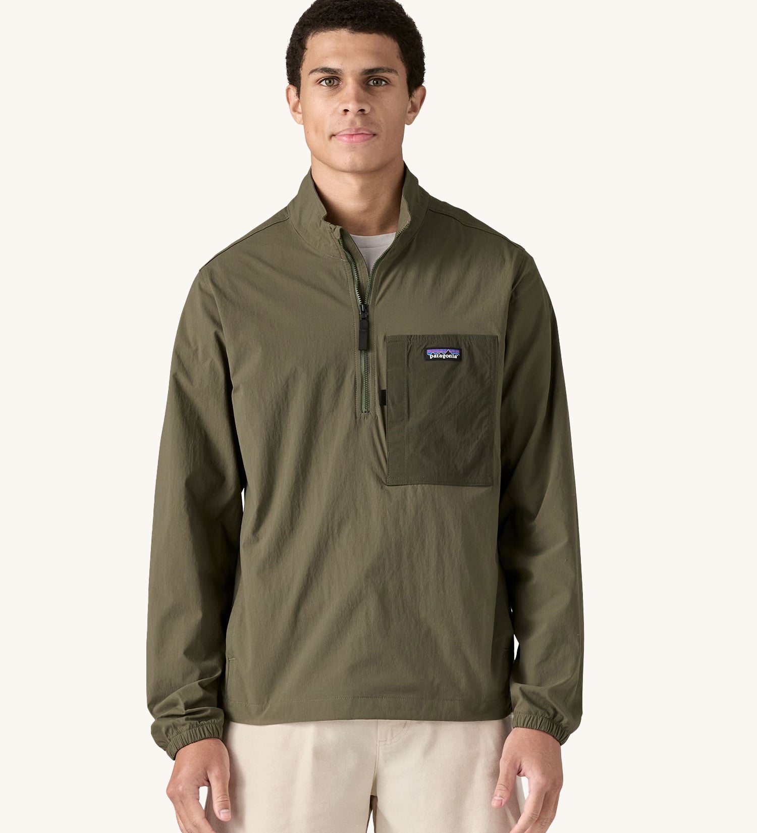 A man wearing the Patagonia Men's Outdoor Everyday Marsupial Pullover in Basin Green.