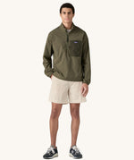 A man wearing the Patagonia Men's Outdoor Everyday Marsupial Pullover in Basin Green.