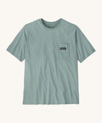 Patagonia men's short sleeve top with a pocket on the front in a light blue colour on a cream background.