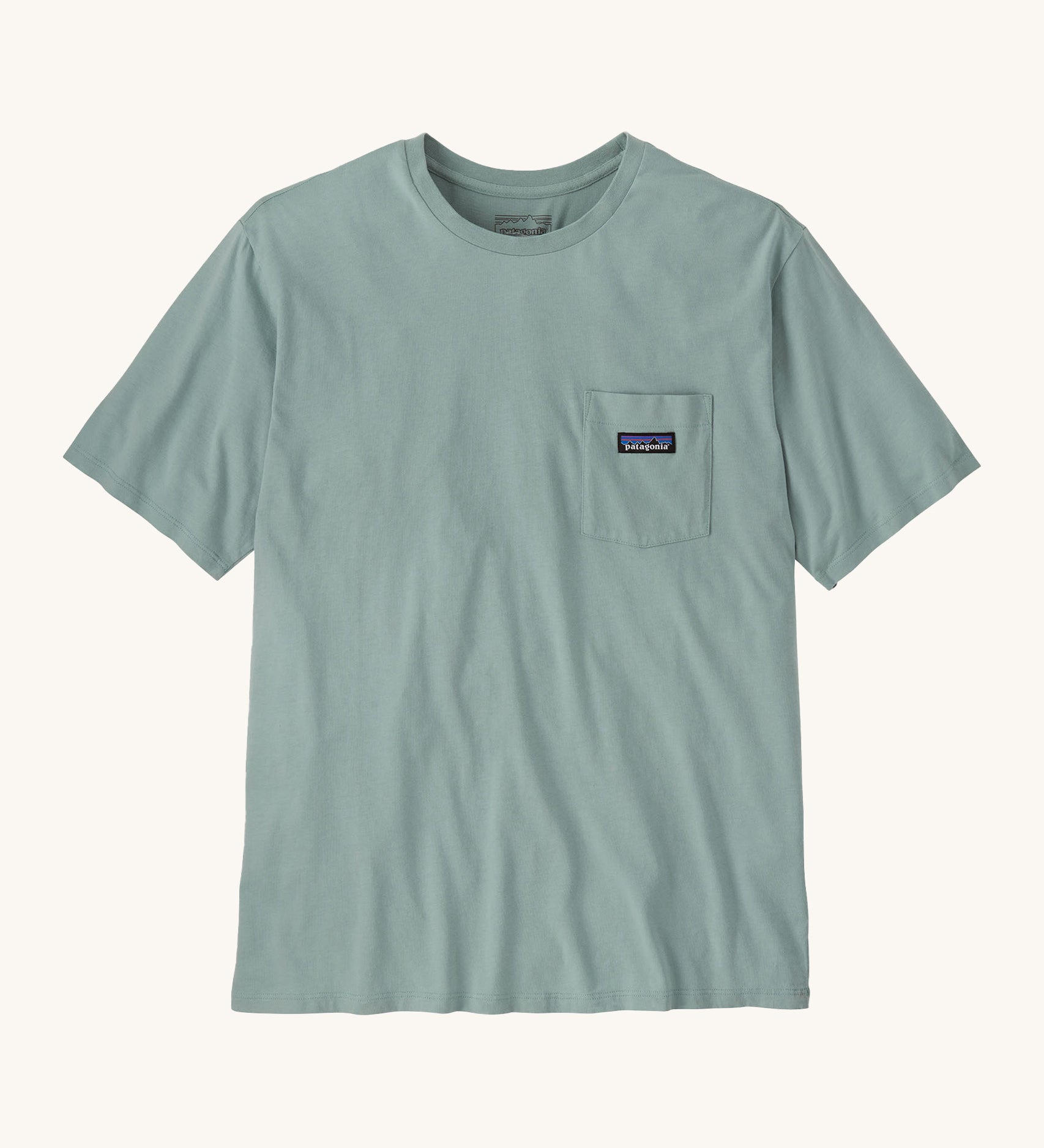 Patagonia men's short sleeve top with a pocket on the front in a light blue colour on a cream background.