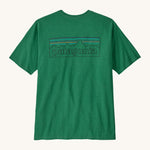 Patagonia men's short sleeve top in green logo outline design on a cream background.