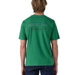 Patagonia men's short sleeve top in green logo outline design worn by a man back detail