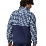 A man wearing a Patagonia Men's Retro Pile 1/2 Snap Pull Over in a New Navy design stood in front of a plain background. He is facing away from the camers showing the back of the pull over top. 