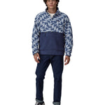 A man wearing a Patagonia Men's Retro Pile 1/2 Snap Pull Over in a New Navy design stood in front of a plain background. He is also wearing dark denim jeans and black coloured trainers. 