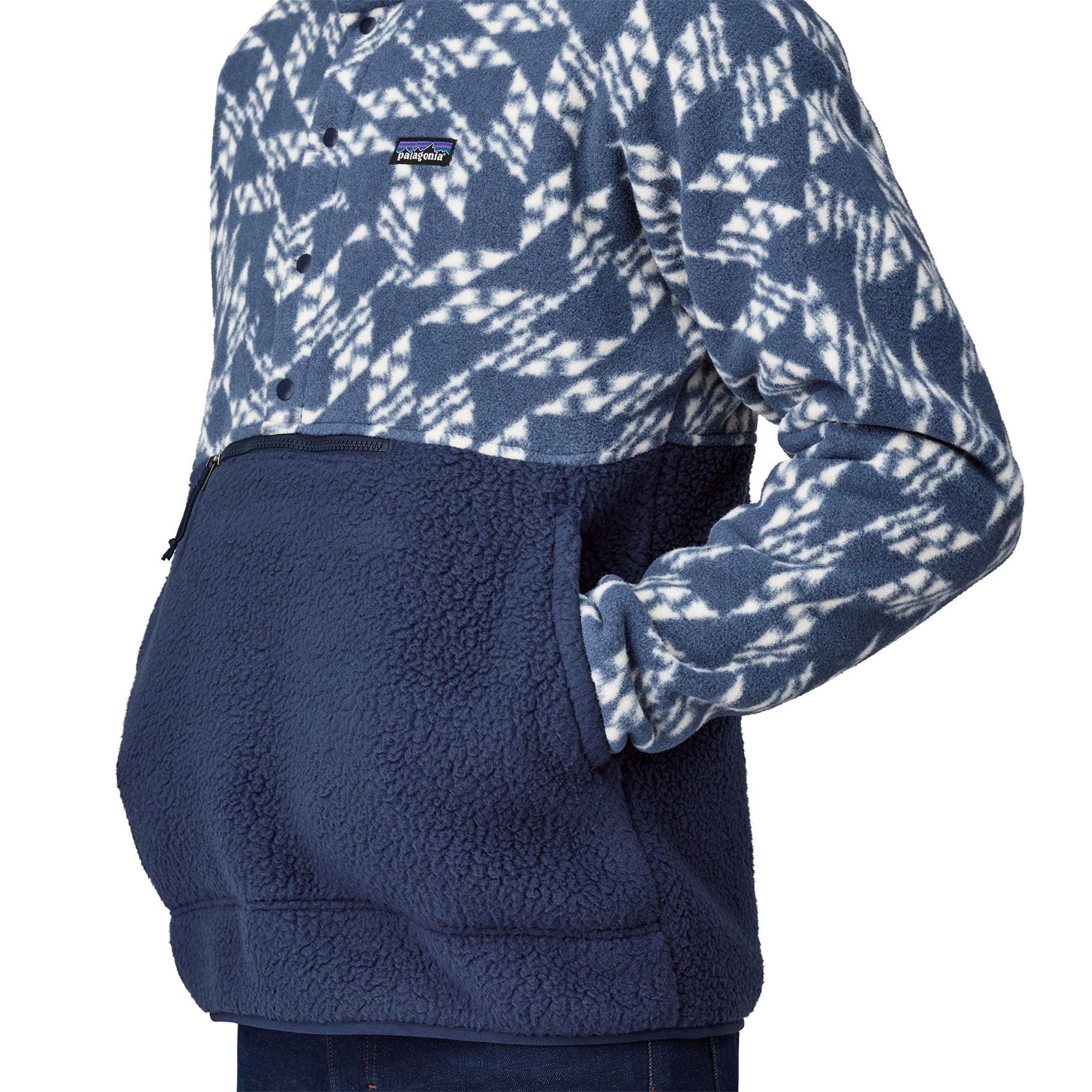 A close up of a person wearing a Patagonia Men's Retro Pile 1/2 Snap Pull Over in a New Navy design.  The person's hand are in the front kangaroo style pocket. 