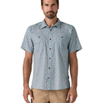 Man wearing the Patagonia Back Step Shirt, made with a blend of 55% industrial hemp and 45% organic cotton. In light blue with an understated Mountain Breeze print, it features short sleeves, coconut buttons, and two chest pockets. 