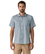 Man wearing the Patagonia Back Step Shirt, made with a blend of 55% industrial hemp and 45% organic cotton. In light blue with an understated Mountain Breeze print, it features short sleeves, coconut buttons, and two chest pockets. 
