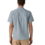 Back of man wearing the Patagonia Back Step Shirt, made with a blend of 55% industrial hemp and 45% organic cotton. In light blue with an understated Mountain Breeze print, it features short sleeves, and a subtle drop tail hem.  