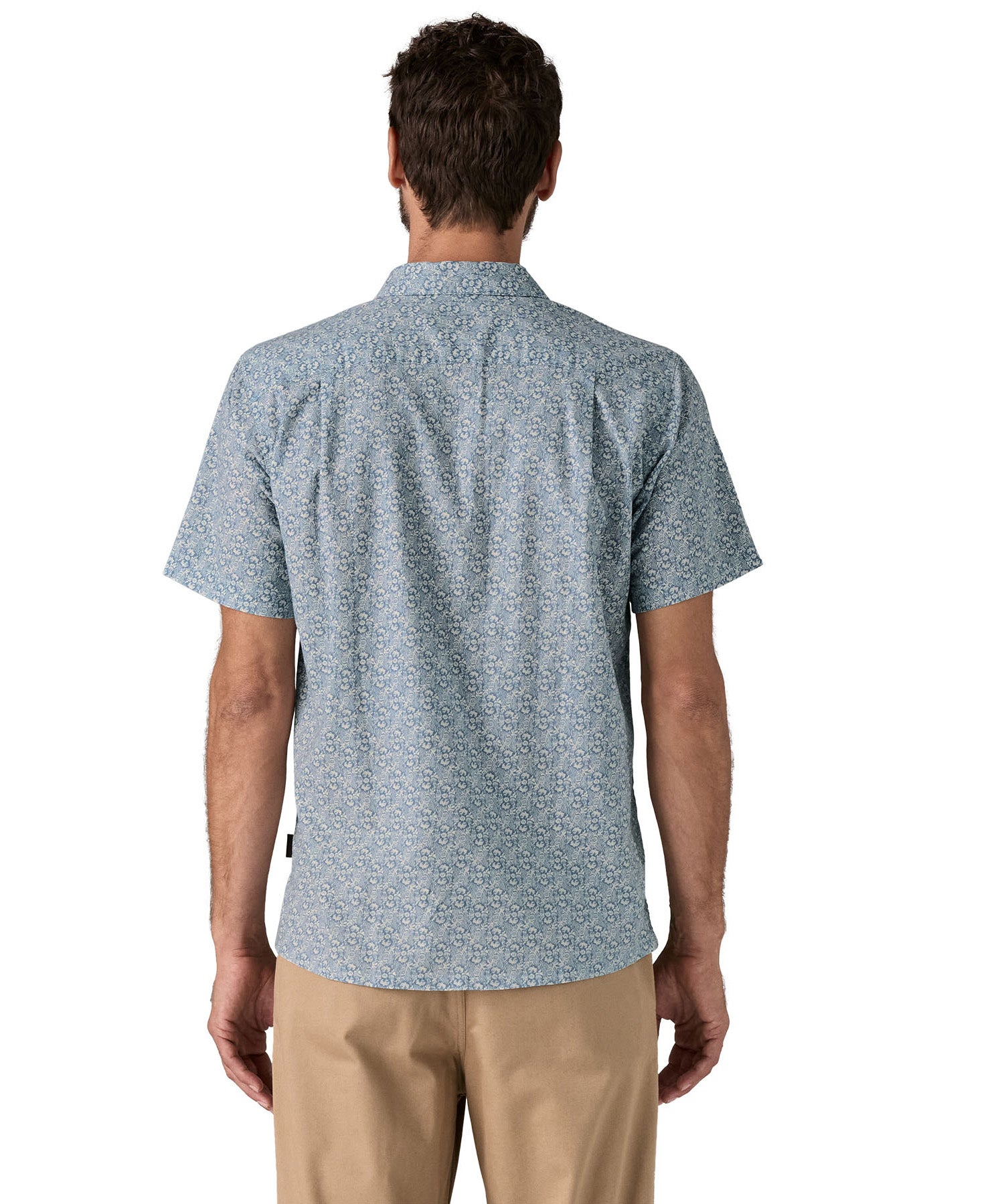 Back of man wearing the Patagonia Back Step Shirt, made with a blend of 55% industrial hemp and 45% organic cotton. In light blue with an understated Mountain Breeze print, it features short sleeves, and a subtle drop tail hem.  