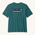 Patagonia mens turquoise short sleeve t-shirt wave design on a cream background.