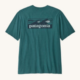 Patagonia mens turquoise short sleeve t-shirt wave design on a cream background.