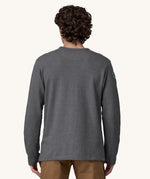 A view of the back of a man wearing a grey coloured Patagonia Men's Wildrise Crewneck Sweatshirt.