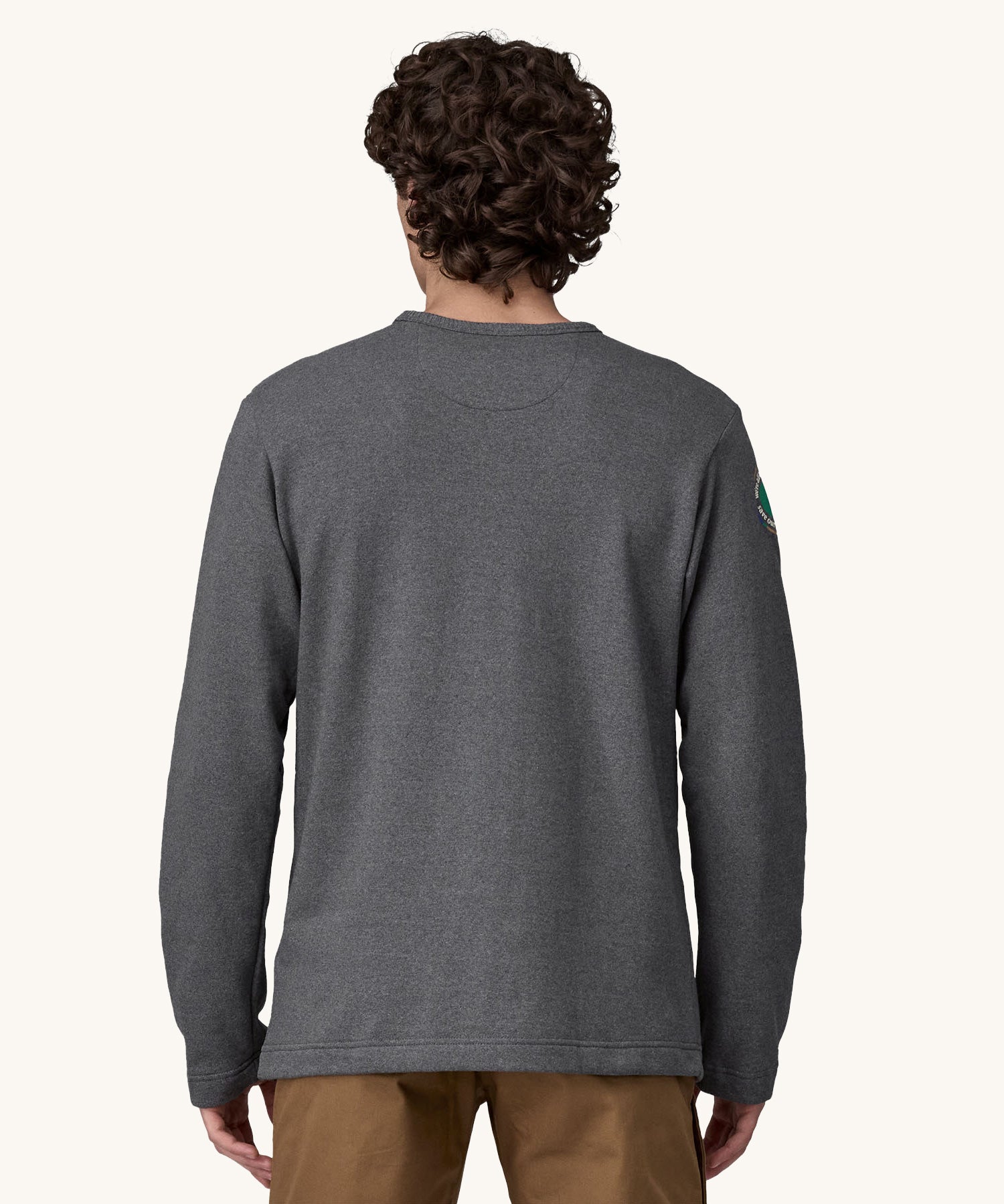 A view of the back of a man wearing a grey coloured Patagonia Men's Wildrise Crewneck Sweatshirt.