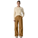 A woman wearing the Patagonia women's trousers available at Babipur. A wide leg style canvas trousers in nest brown colour, features a button fastener and 2 side pockets. 