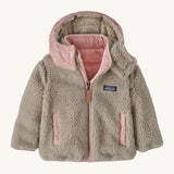 Patagonia little kids tribbles hoody. A reversible coat showing the natural fleece alternative side. Features a logo patch on the chest and 2 side pockets with popper fastenings