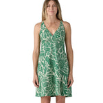 Model wearing the Patagonia Amber Dawn dress that has a green floral / leafy pattern.