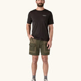 Man wearing the Patagonia Men's Outdoor Everyday Shorts in Pine Needle Green. He has a hand in one of the front pockets.
