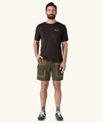 Man wearing the Patagonia Men's Outdoor Everyday Shorts in Pine Needle Green. He has a hand in one of the front pockets.
