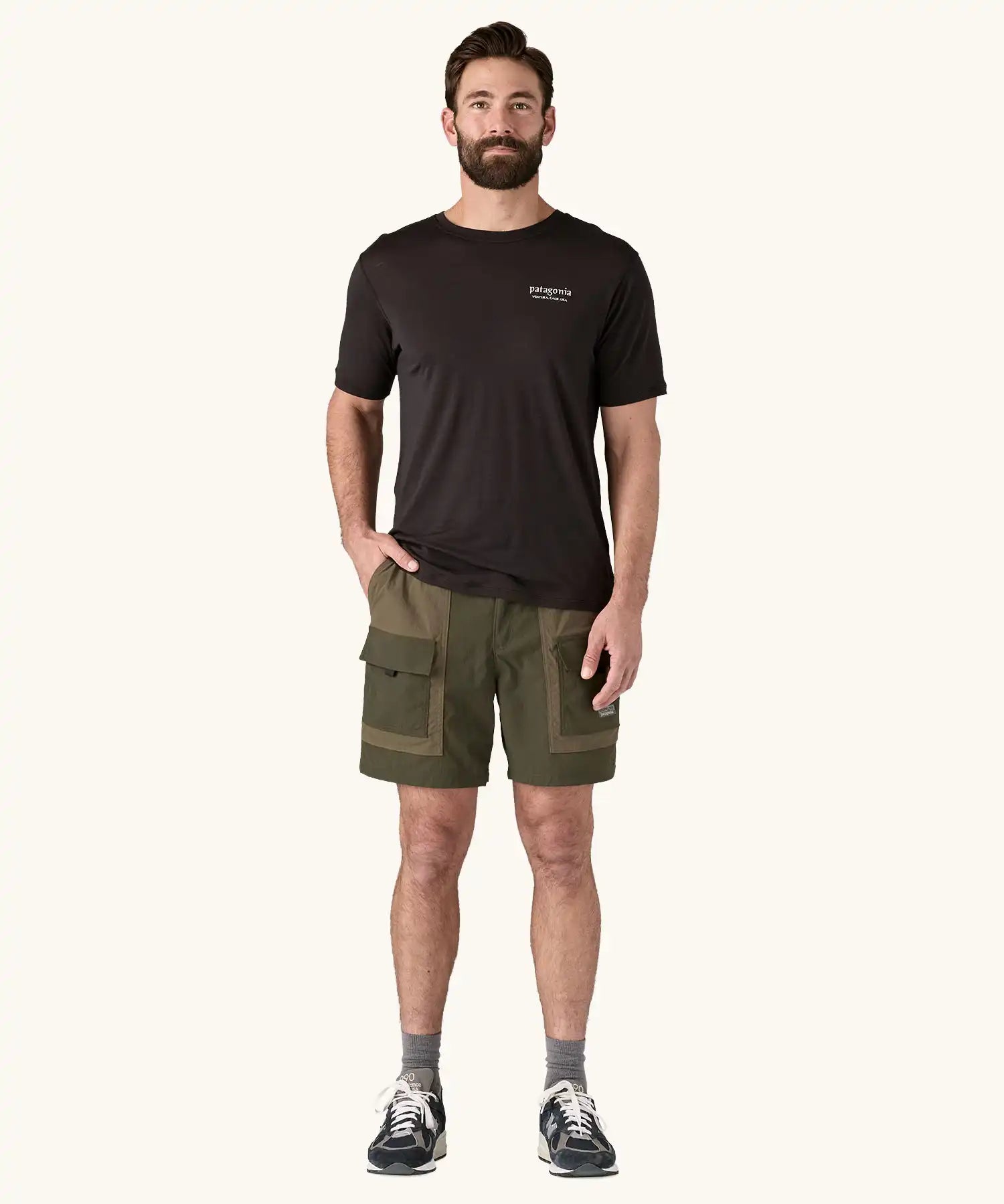 Man wearing the Patagonia Men's Outdoor Everyday Shorts in Pine Needle Green. He has a hand in one of the front pockets.