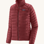 Patagonia women's down sweater jacket in oxide red colour on a cream background.