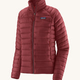 Patagonia women's down sweater jacket in oxide red colour on a cream background.