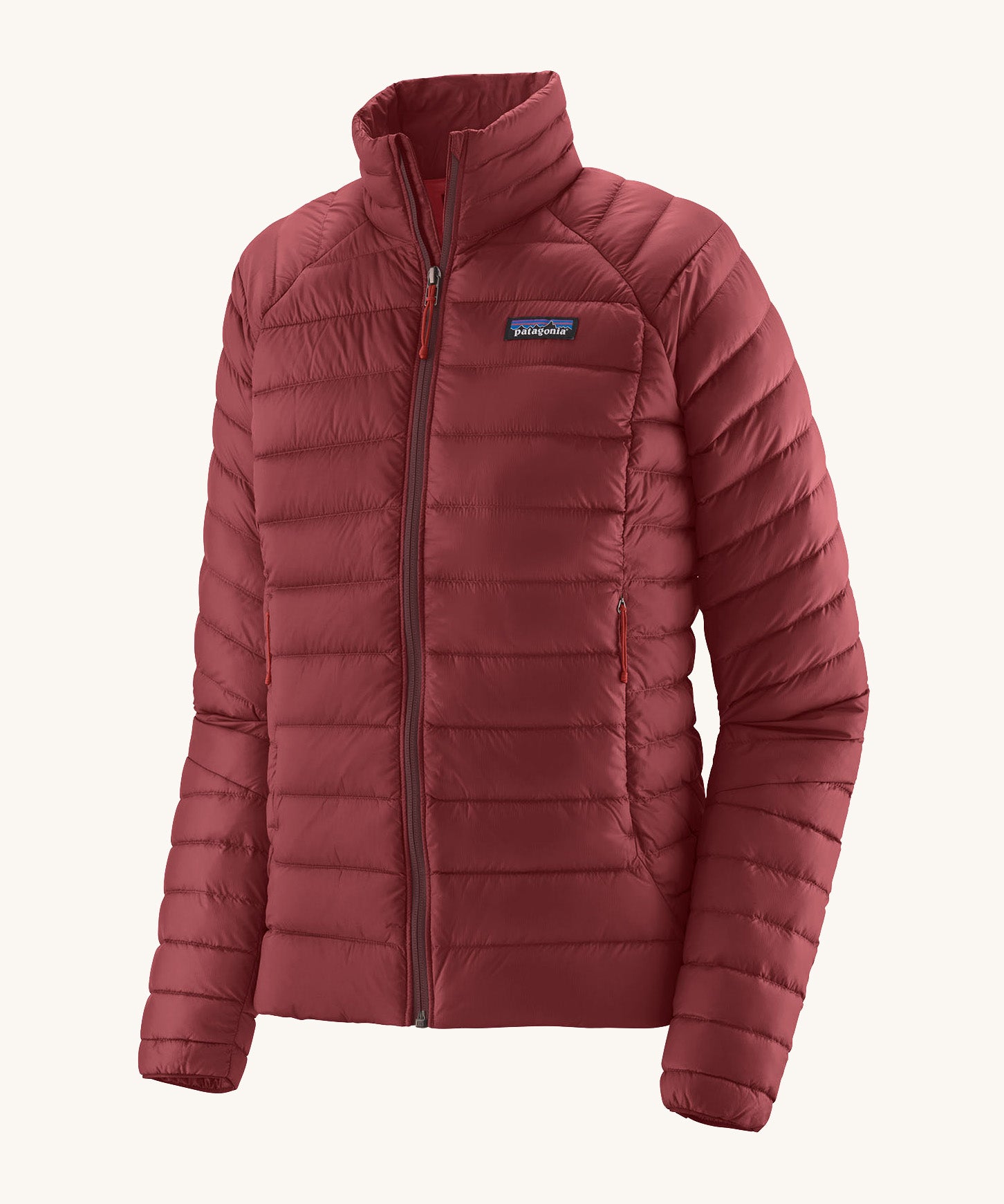 Patagonia women's down sweater jacket in oxide red colour on a cream background.