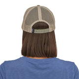 view of the back of a person wearing a Patagonia P-6 Logo LoPro Trucker Hat in a stone beige colour way