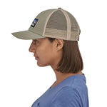 side profile of a person wearing a Patagonia P-6 Logo LoPro Trucker Hat in a stone beige colour way