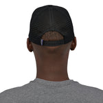 A back profile image of a man wearing the Patagonia P-6 Logo Trucker Hat in a Black colour