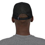A back profile image of a man wearing the Patagonia P-6 Logo Trucker Hat in a Black colour
