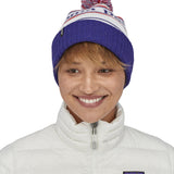 An adult wearing the Patagonia park stripe viking blue. Features a red, white and blue pom pom pom and blue turn up ribbed brim