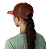The back of the woman wearing the Patagonia adult red potters hat. A trucker style cap with a mesh back and logo embroidery on the front panel available at Babipur.