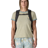 Woman wearing the Patagonia's 26L refugio backpack in dark blue with matching chest strap and quick release buckle.