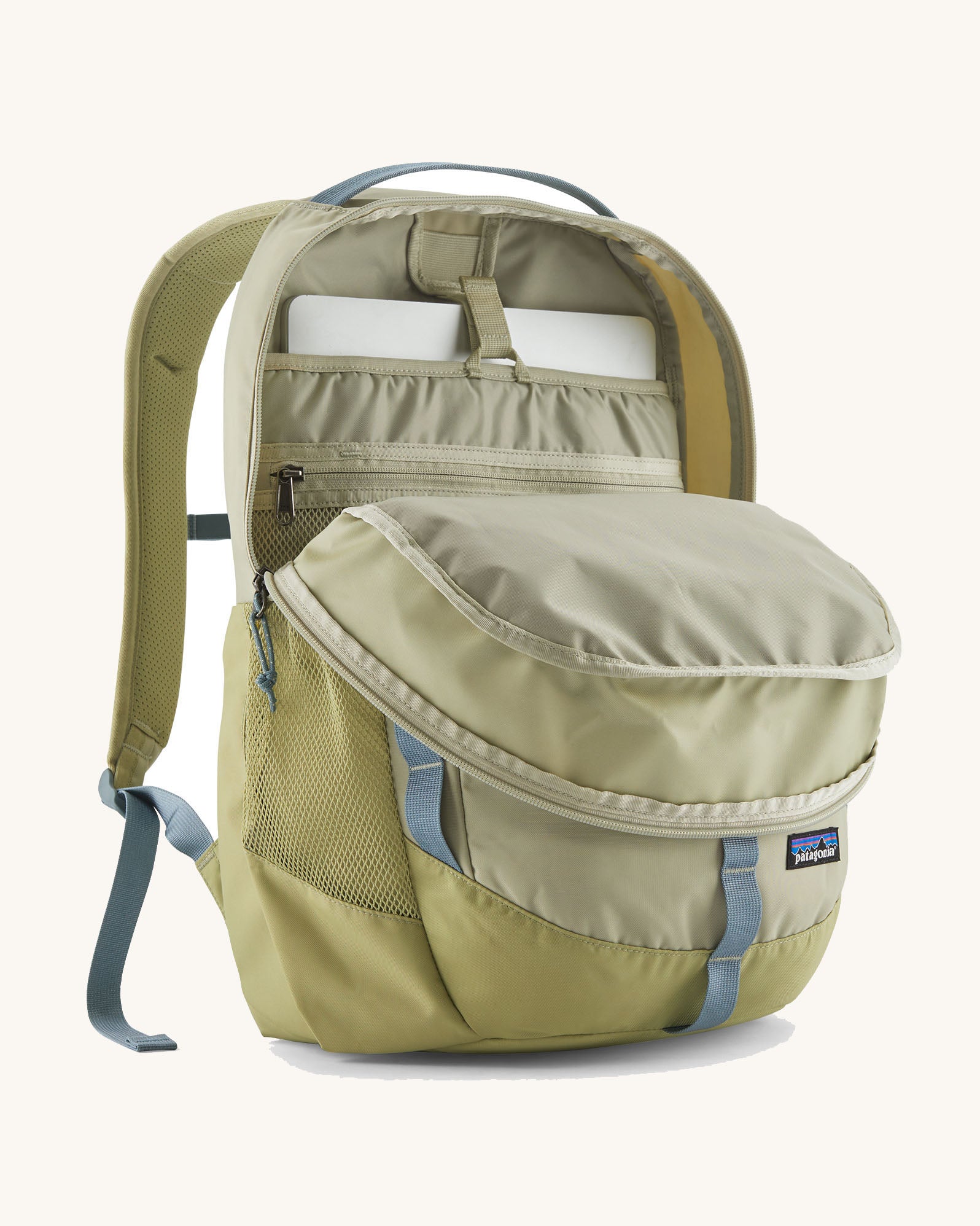 Patagonia refugio 26L back pack in stone with the main compartment open and a laptop in the sleeve at the back.